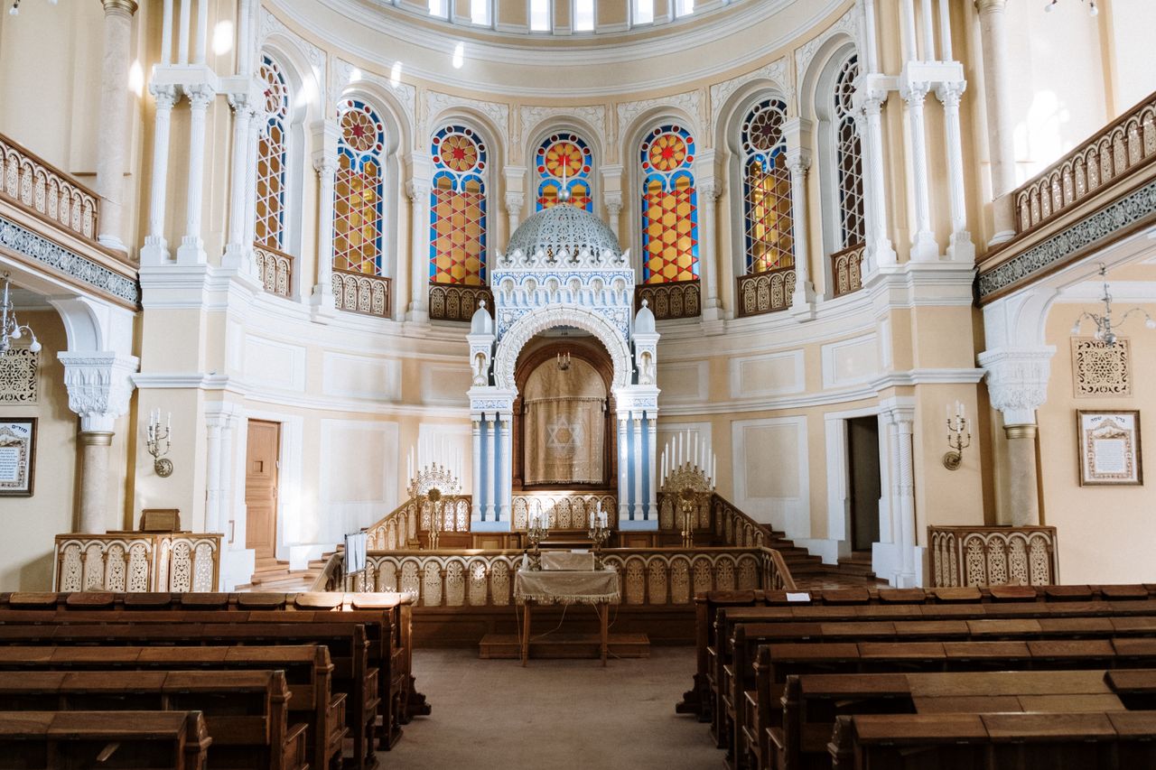 Explore the intricate design and architecture of a historic synagogue's interior, featuring vibrant stained glass.