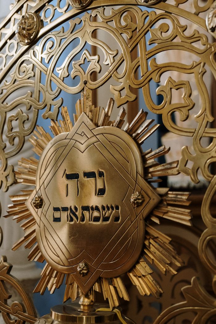 Close-up of an ornate gold Hebrew symbol inside a synagogue highlighting Jewish culture.