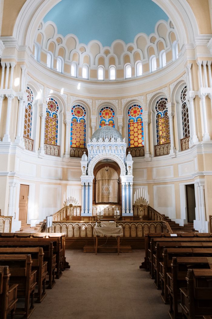 Captivating synagogue interior showcasing stained glass and architectural details.
